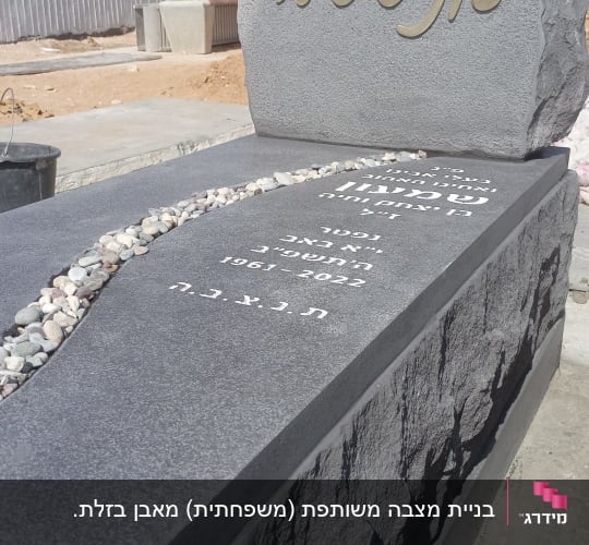 מצבה עם כיתוב בעברית ואבנים קטנות